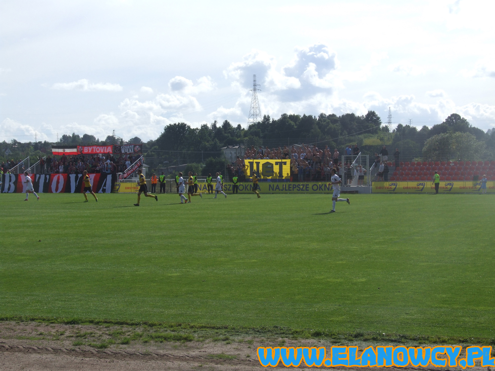 Bytovia Bytów - Elana Toruń 3:0 (1:0)
Bytovia Bytów - Elana Toruń 3:0 (1:0)
1:0 Kajca (22), 2:0 Kaganek (47), 3:0 Kowalski (54)

Do Bytowa wybrało się 101 kibiców Elany w tym 4 chłopaków z WfcG (dzięki za wsparcie), na stadion wbiło się 92 fanów a reszta została w autokarze lub kršżyła po okolicy. Na płocie powiesiliśmy wyjazdową flagę W(E)T i trochę dopingowaliśmy z małą wymianą "uprzejmości" z miejscowymi, których młyn znajdował się kilka metrów od nas i liczył ok 60 osób. W drugiej połowie i po meczu ciśniemy z opiekunem drużyny (trenerem go raczej nazwać nie można), dla którego najważniejsze jest "komentowanie" w Polsacie... Grajki w fatalnym stylu przegrywają mecz, po którym dziękują nam za wsparcie. Podróż w obie strony z wahadłem. Pozdrowienia dla obecnych!


